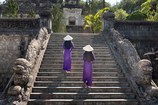 两名身着传统服装的妇女登上石阶，来到一座古庙，感受文化遗产