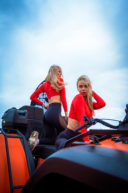 Two women in red outfits on a red and black atv