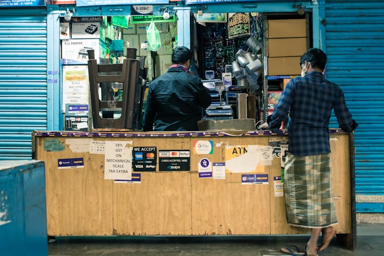 Men At A Stand In A Mall