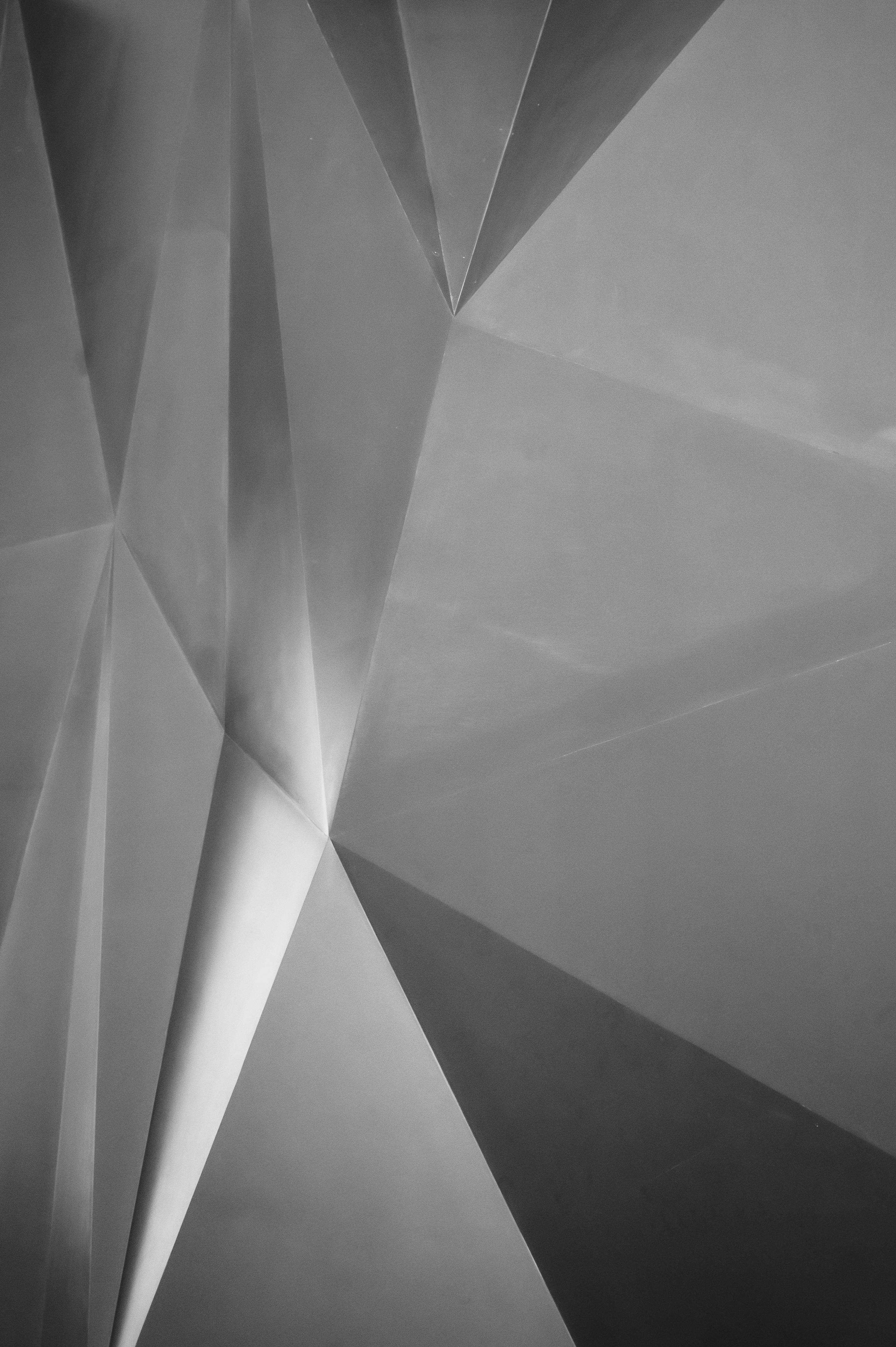 An abstract black and white geometric pattern, featuring sharp angles and intersecting lines.