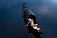 黄昏时分，平静的河面上，一艘传统船只点亮了蜡烛