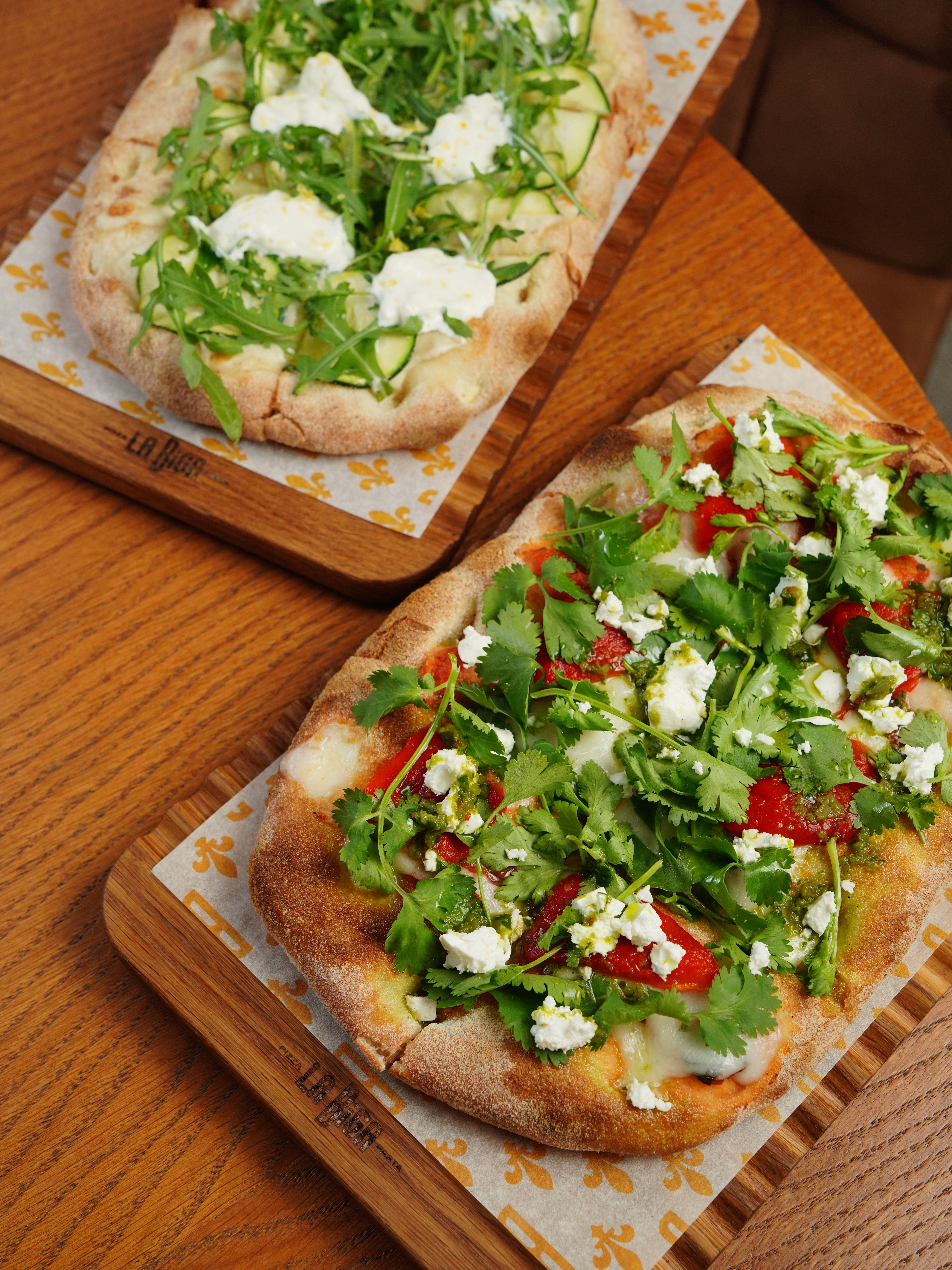 Two Pinsas with Different Toppings Lying on Cutting Boards · Free Stock ...