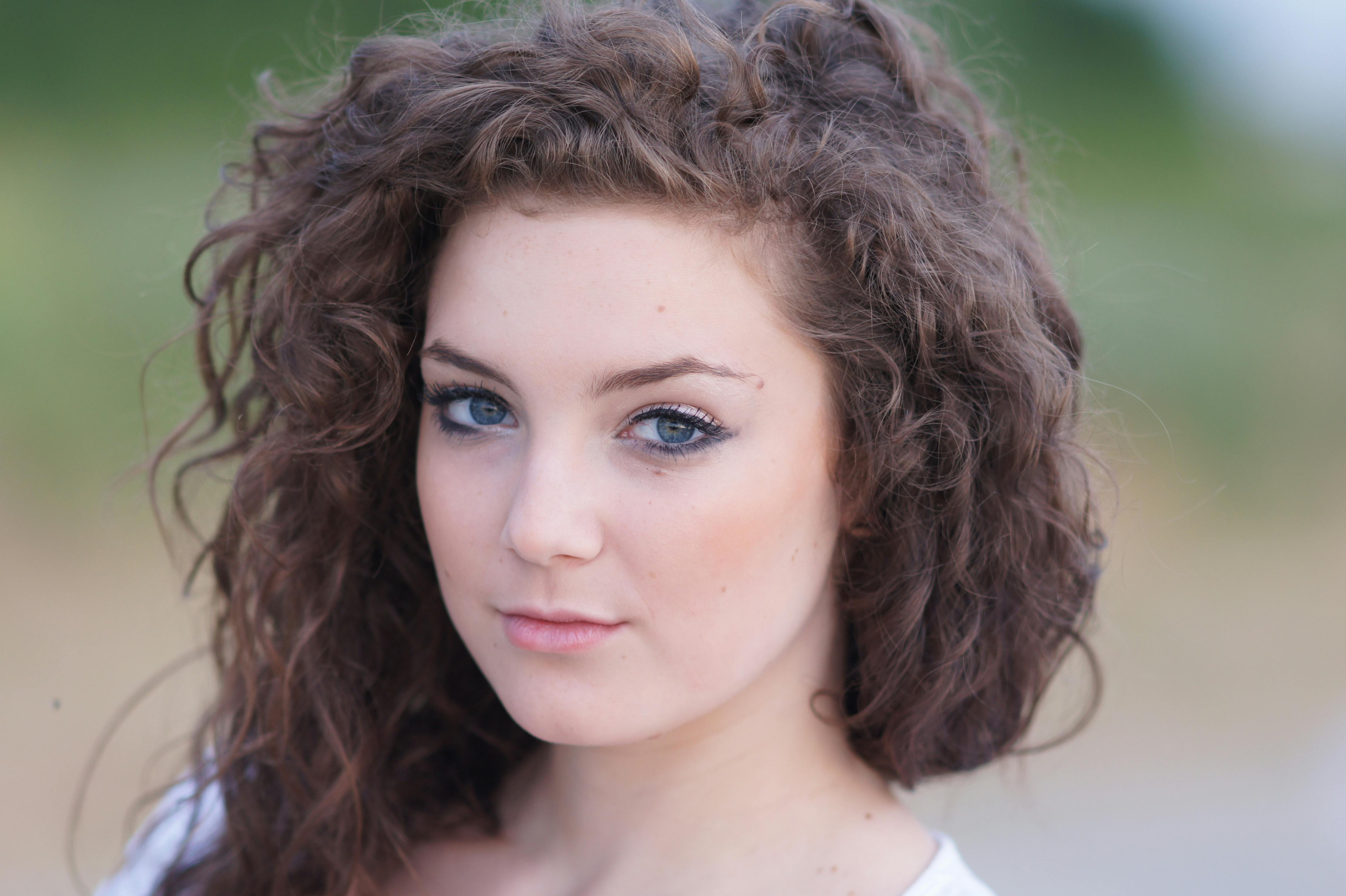 a woman with curly hair and a white shirt