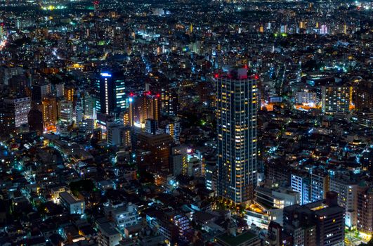 Stunning aerial view of Tokyo's vibrant cityscape at night, showcasing illuminated skyscrapers.