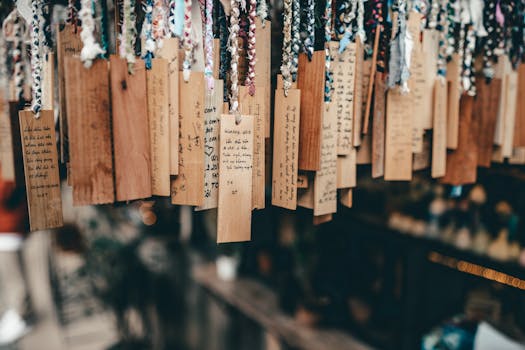 Hanging wooden tags with handwritten text in a vibrant Dalat market scene.