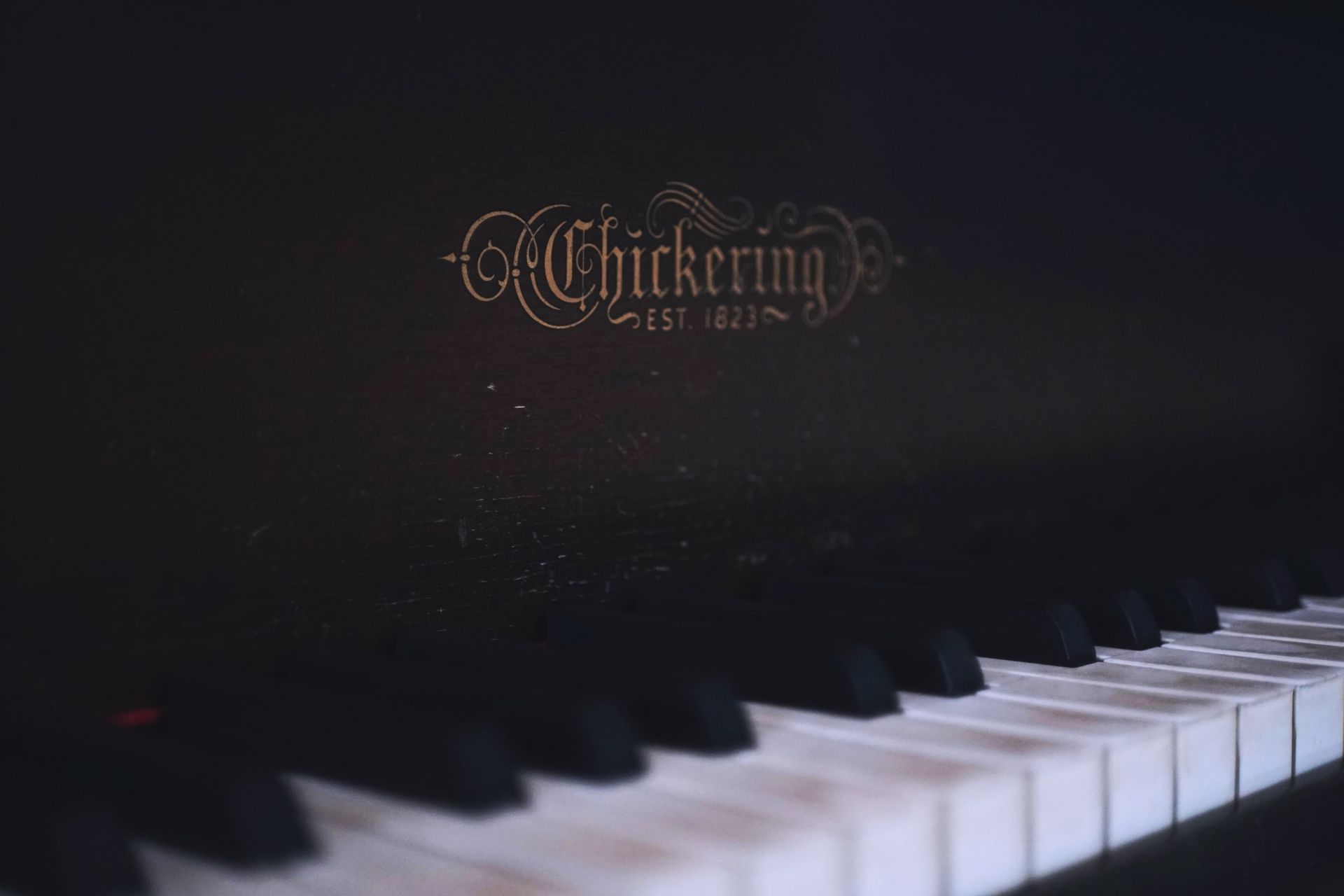 Detailed close-up view of a classic Chickering piano keyboard with elegant dark tones.