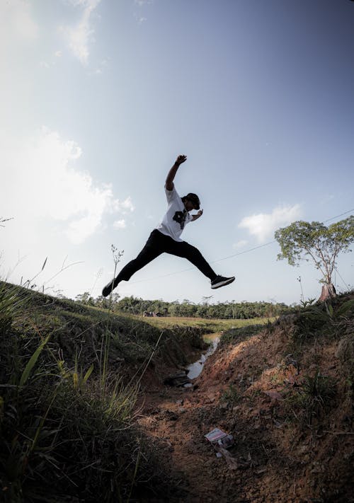 A person jumping in the air over a dirt path