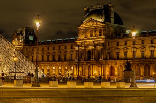 The louvre at night with the pyramid in the background