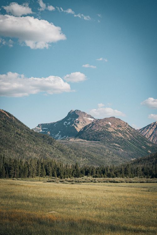 Free Breathtaking view of mountains and fields under a clear blue sky, perfect for nature lovers. Stock Photo