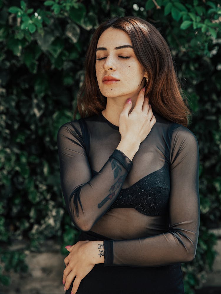 Young Woman In A Mesh Blouse Standing Outside 