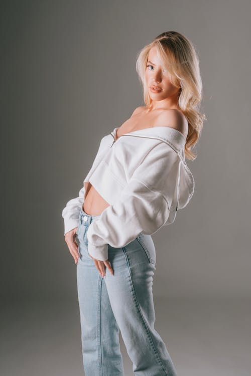 A beautiful blonde woman in jeans and a white sweatshirt