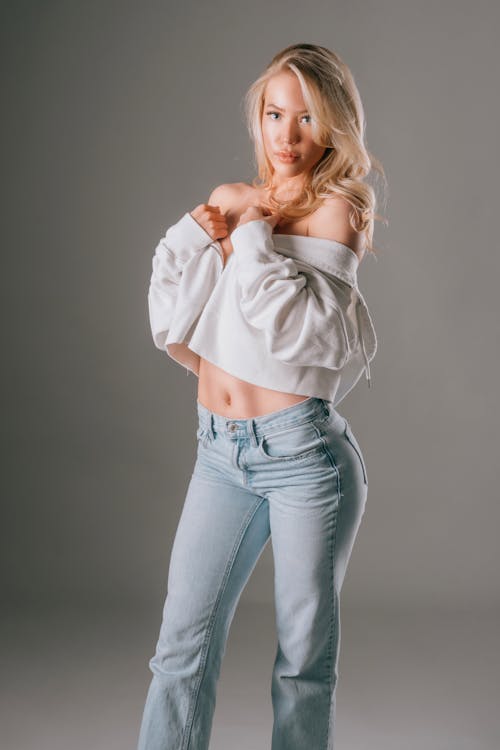 Kostnadsfri bild av blond, grå bakgrund, jeans