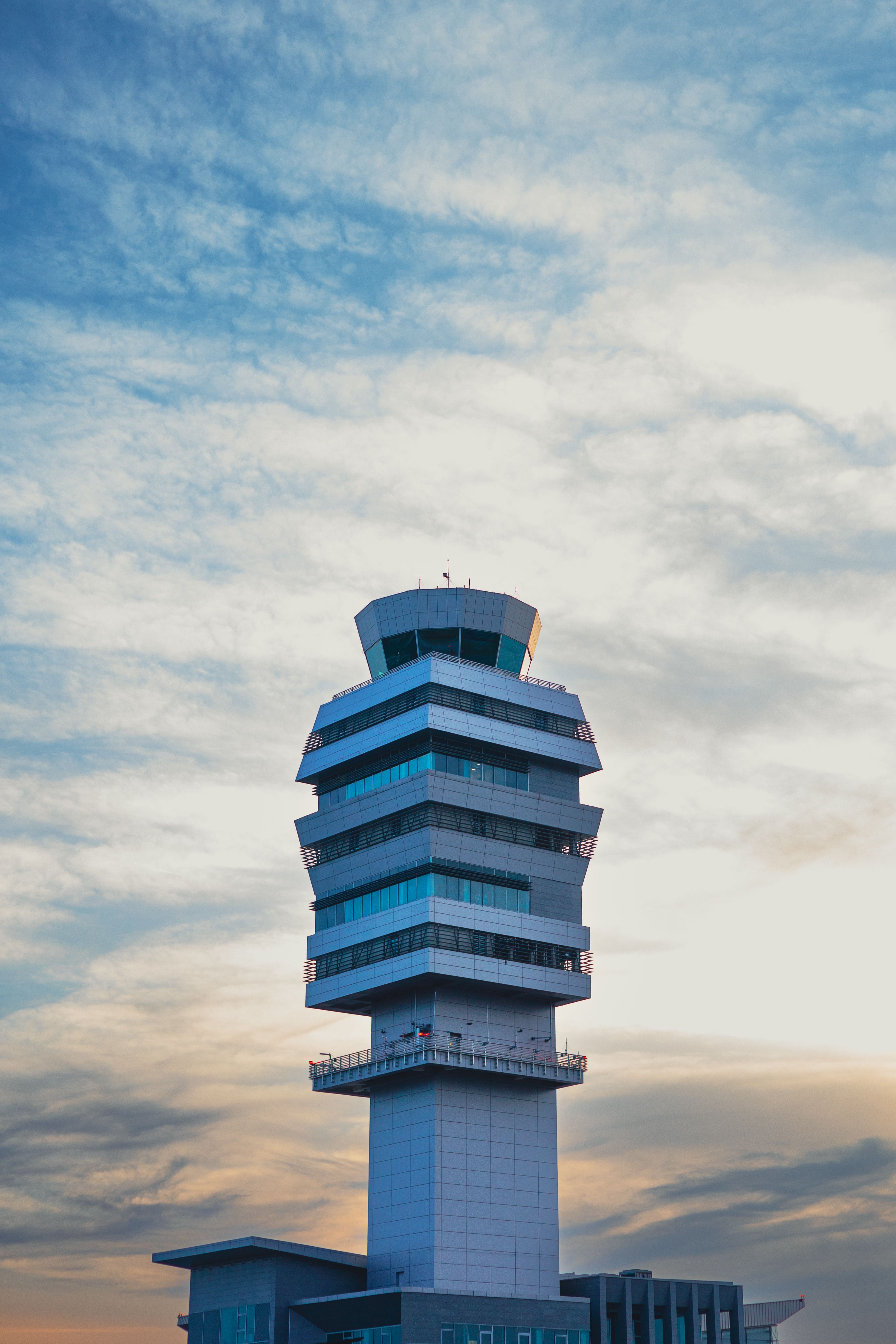 A modern control tower in Belgrade, Serbia, stands against a serene sky at twilight.