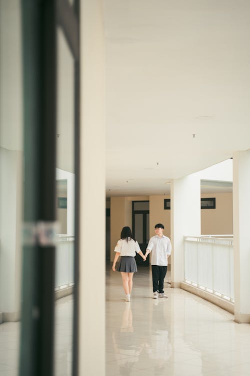 Man in Shirt and Woman in Skirt Holding Hands