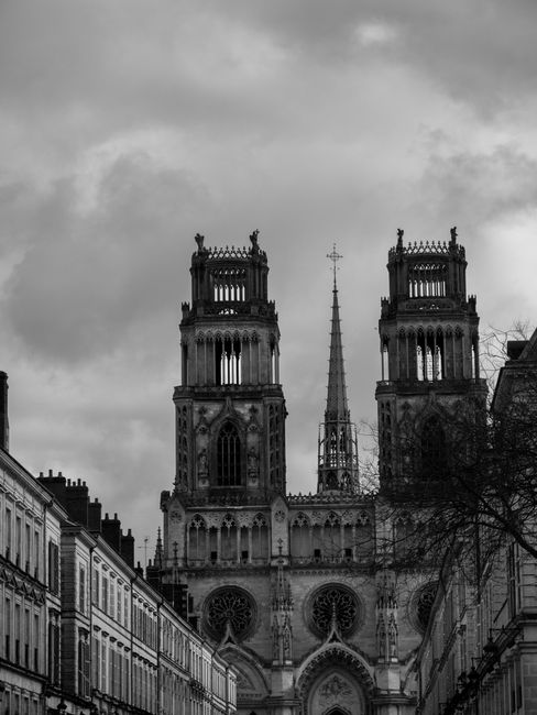 Dramatic view of Gothic cathedral towers in a Paris cityscape.