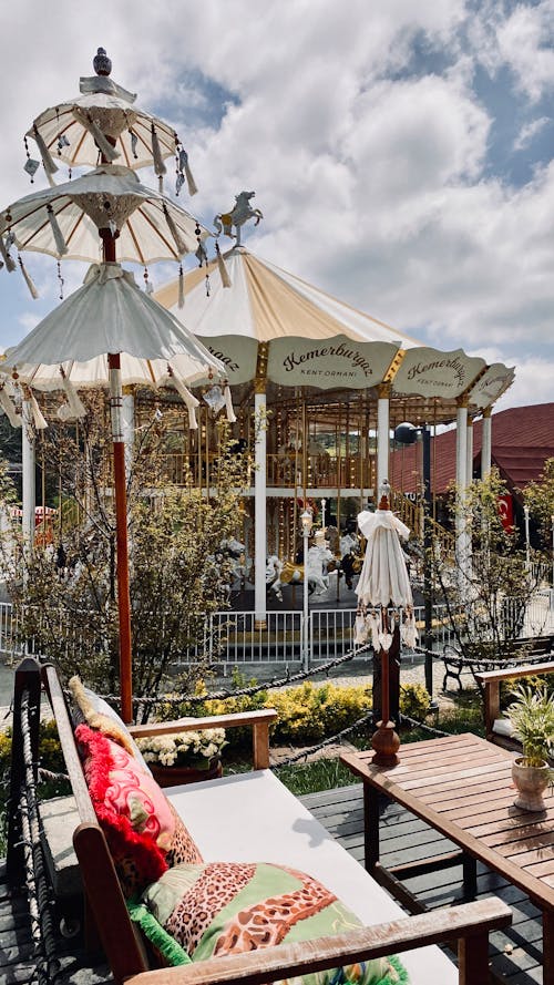 A carousel is sitting on a patio with chairs