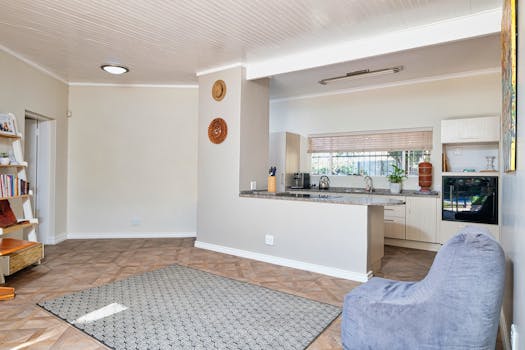 Spacious modern kitchen and living area with minimalist decor and natural light.