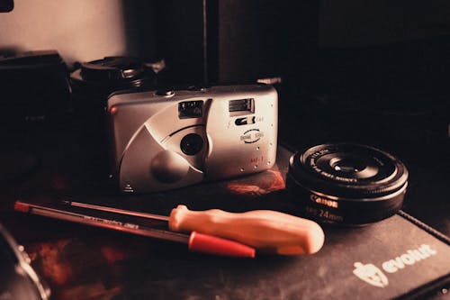 A camera, a pen and a screwdriver on a table