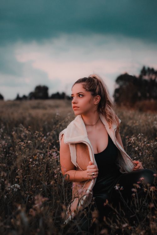 Free Portrait of a woman in a field during sunset, showcasing natural beauty and serene landscape. Stock Photo
