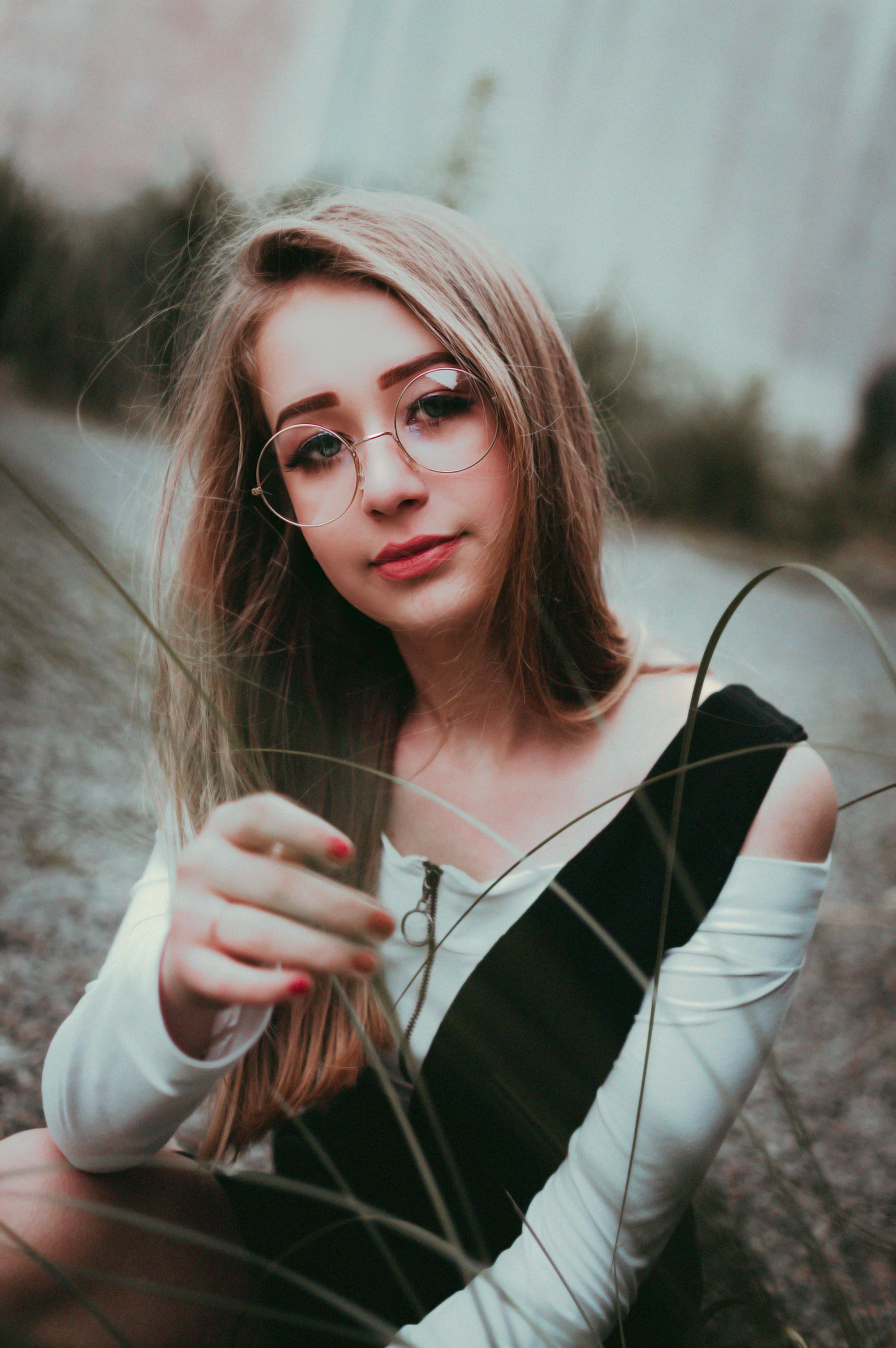 Miễn phí Một Cô Gái Trẻ đeo Kính Ngồi Bên Ngoài  Ảnh lưu trữ