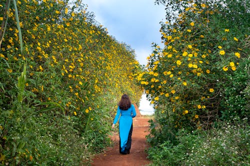 花の横を歩く女性