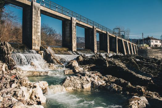 Scenic view of a hydroelectric dam in Danilovgrad, Montenegro, showcasing flowing water and rocky landscape.