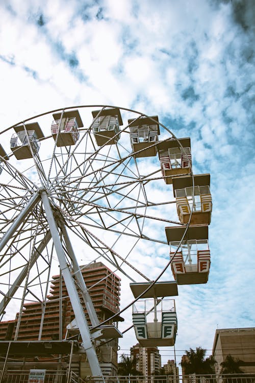 A ferris wheel in the sky with buildings in the background
