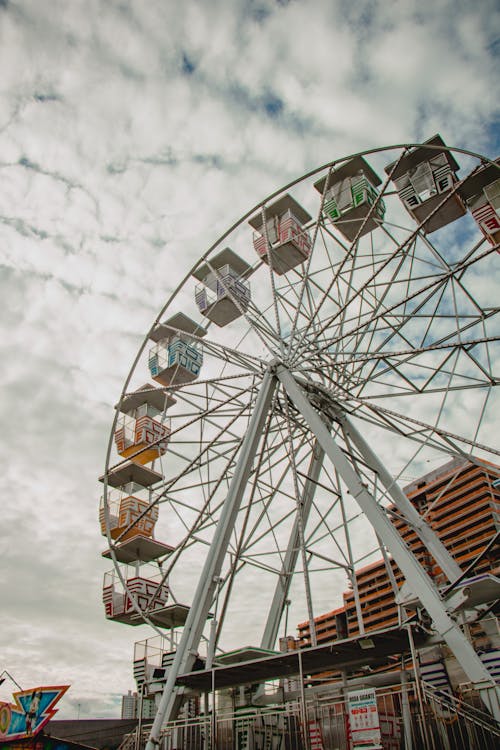 A ferris wheel is in the sky with a cloudy sky