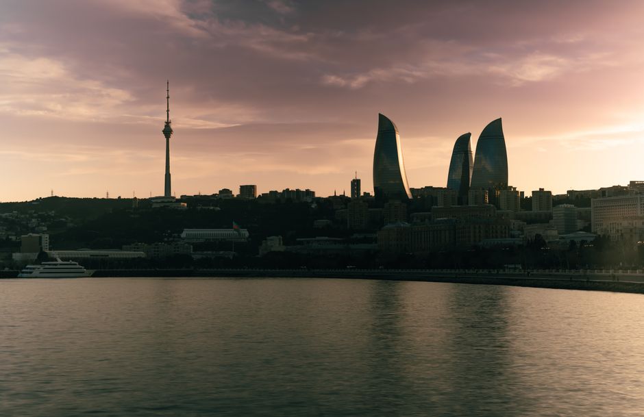 Breathtaking view of Baku skyline featuring iconic Flame Towers and TV Tower at sunset.