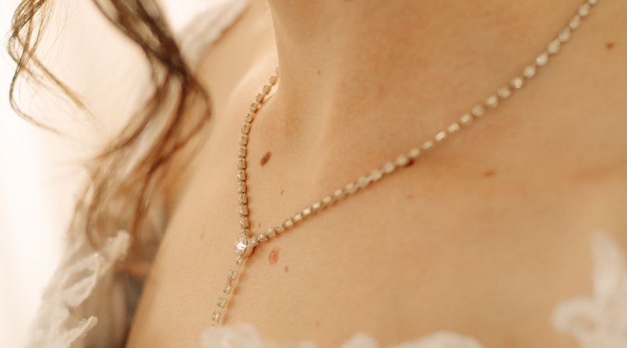 Gros plan sur une mariée portant un collier doré et des boucles d'oreilles élégantes