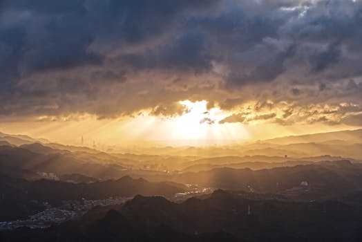 Golden sunlight beams through clouds over Taiwan's dramatic hills.