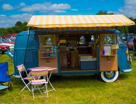 Charming vintage camper van set up as a pop-up café with outdoor seating, showcasing 1960s nostalgia.