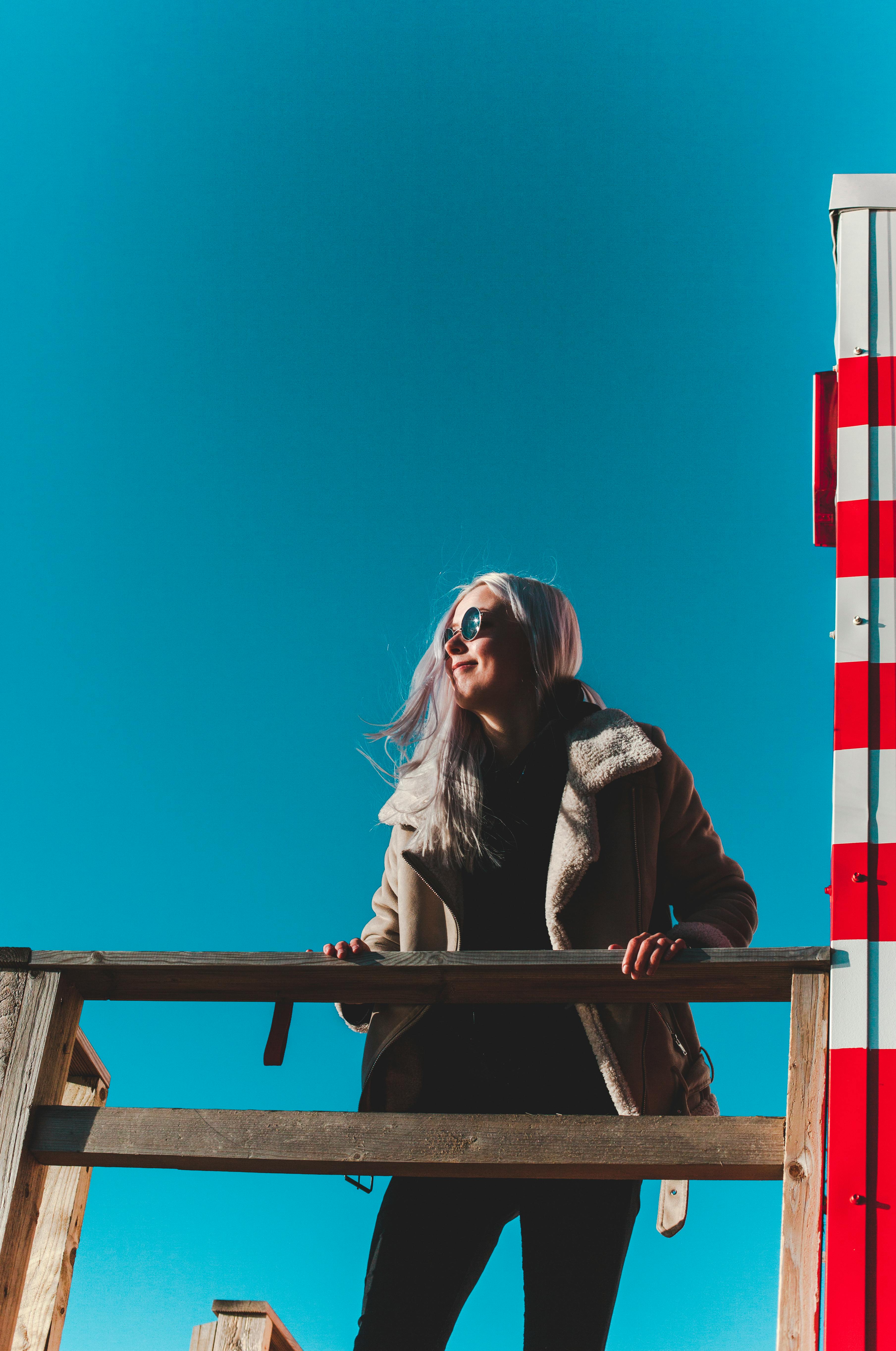 一位戴着太阳镜的时尚女士在爱沙尼亚塔林享受着阳光明媚的一天