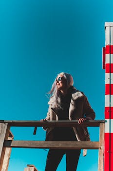 一位戴着太阳镜的时尚女士在爱沙尼亚塔林享受着阳光明媚的一天