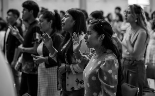 Free A group of women with eyes closed and hands raised in prayer at a church in Ciudad de México. Stock Photo