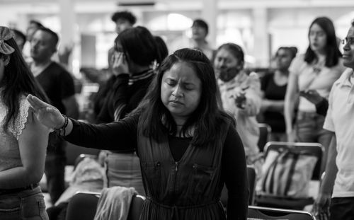 Free Woman praying in a serene religious gathering in Mexico City, showcasing diverse cultural unity. Stock Photo