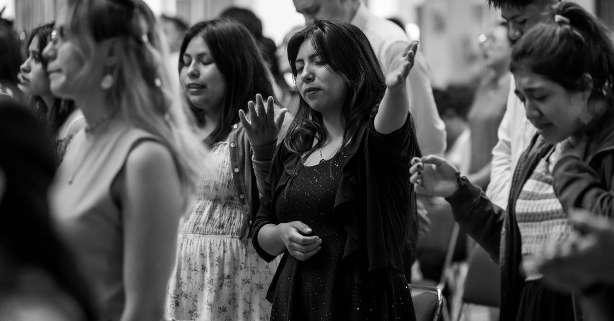 diverse group of people praying together in a dimly lit church, candid documentary photography