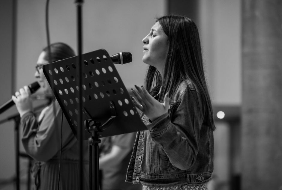 A passionate singer performing live in black and white at a concert in Mexico City.