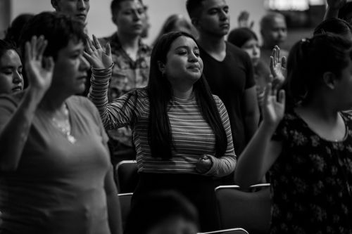 Free A contemplative group with raised hands during a religious assembly in Mexico City. Stock Photo