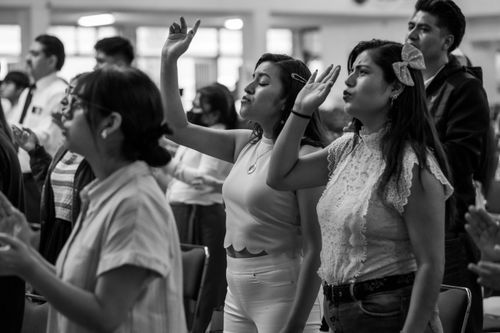 Free Adults engaged in a religious gathering with hands raised in Ciudad de México. Stock Photo