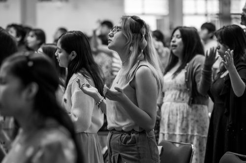 Free A group of women in Ciudad de México are praying with eyes closed, hands raised, indoors. Stock Photo