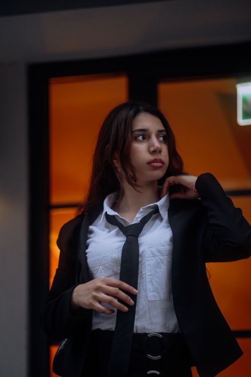Free Portrait of an elegant woman in business attire posing indoors with a thoughtful expression. Stock Photo