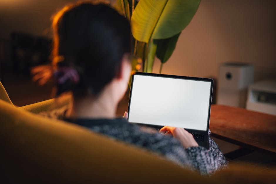 How QuickBooks Solves Tax Tracking for Freelancers A woman using a laptop in a comfortable home setting, showcasing a relaxed and focused work environment.