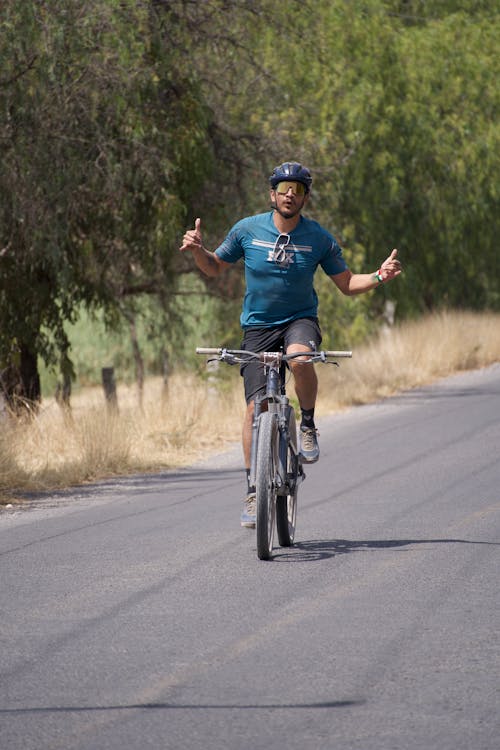 A man riding a bike on a road with a smile