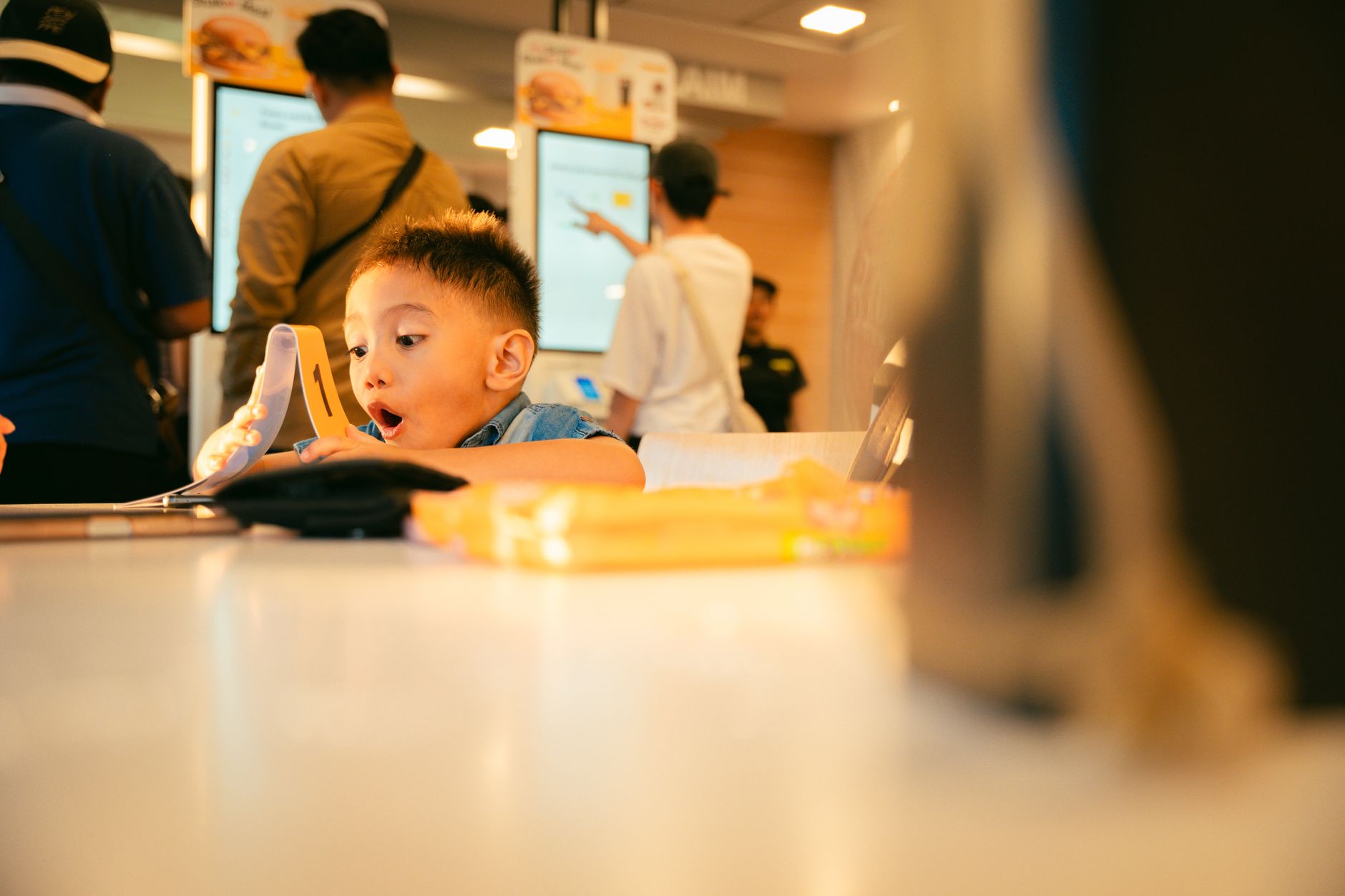 Family happily eating Happy Meals with toys on table