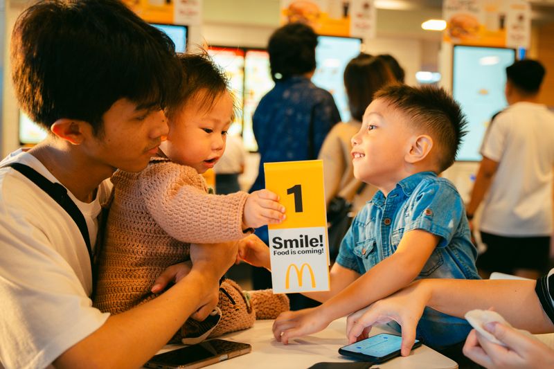 Father and children sharing a joyful moment at a fast food restaurant.