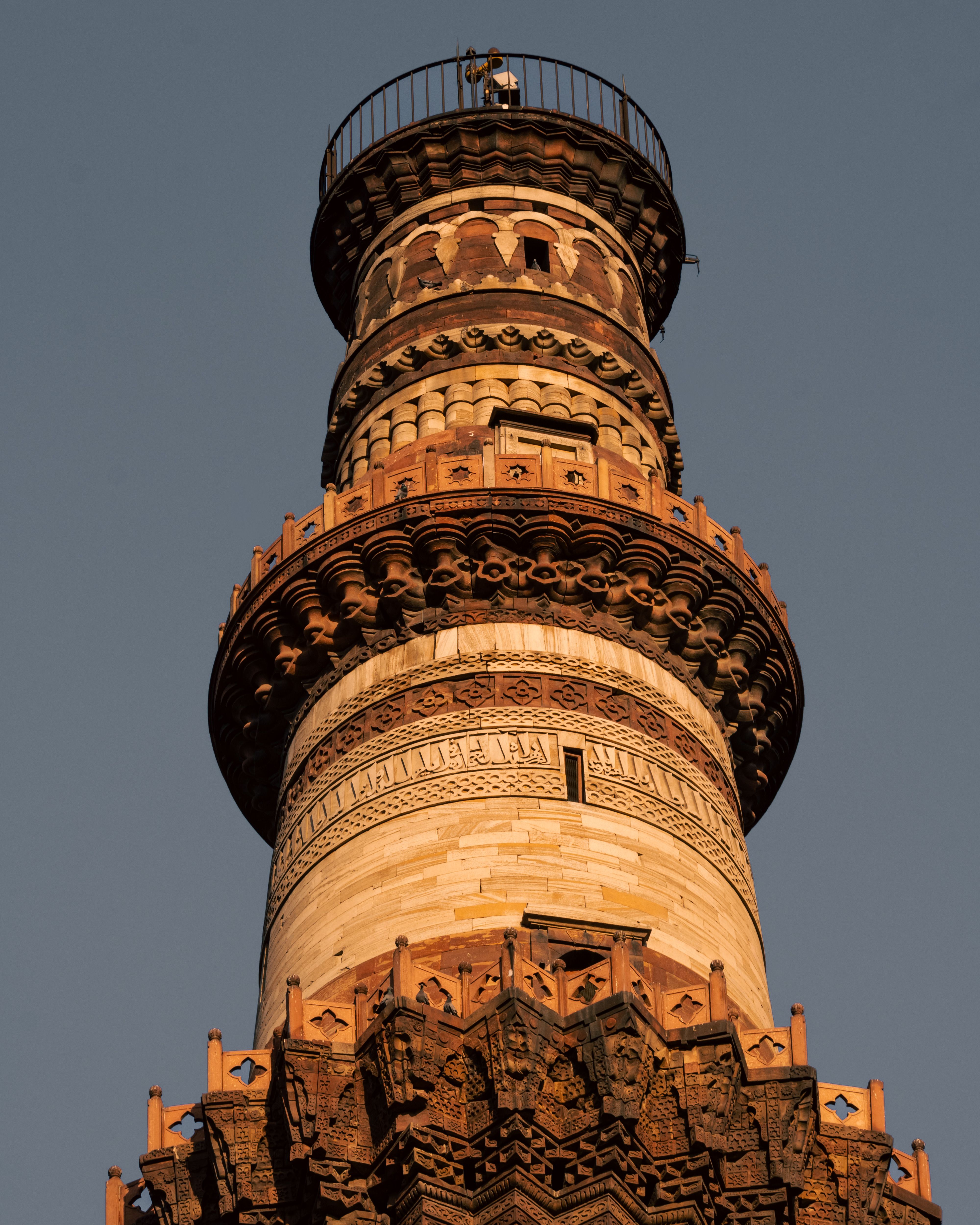 Low angle view of Qutub Minar's intricate architecture in New Delhi, India.