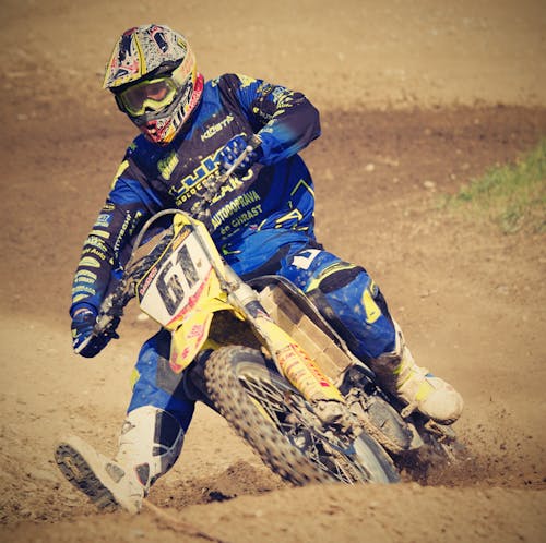 Free Man in Blue Motorcycle Suit Riding on Yellow Dirt Motorcycle during Daytime Stock Photo