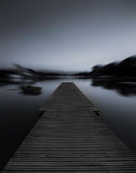 黎明时分，木制码头延伸至雾湖中，呈现出一片宁静的黑白景象