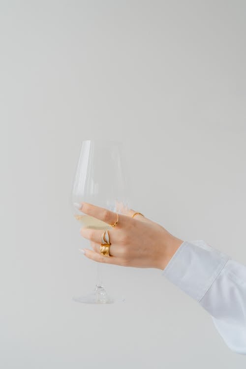 Woman Hand Holding Glass of Champagne on White Background
